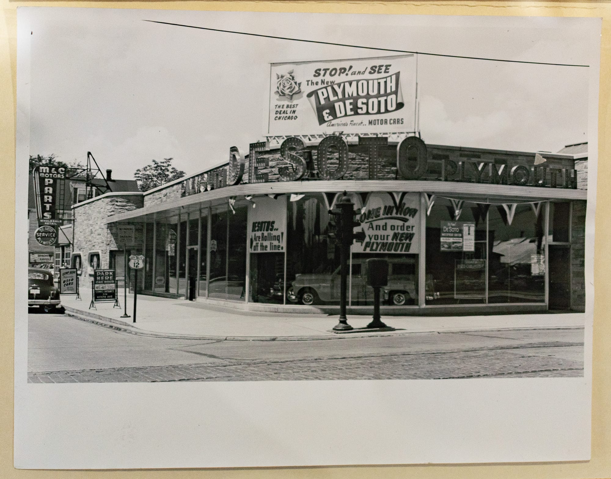 Black and white photo of the building with signs on the street, the sign text is different.