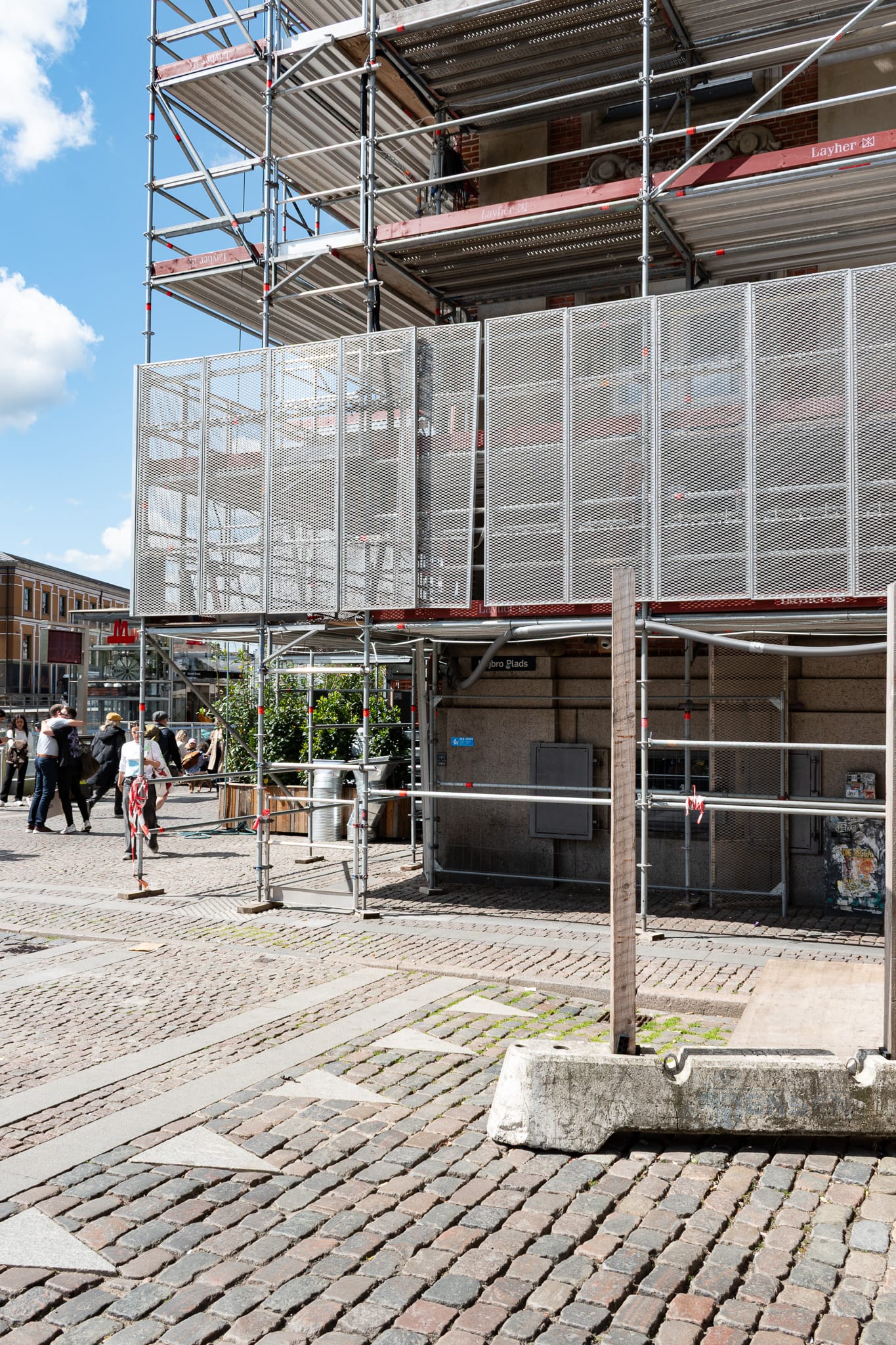 Cobblestone street and a building covered in scaffolding